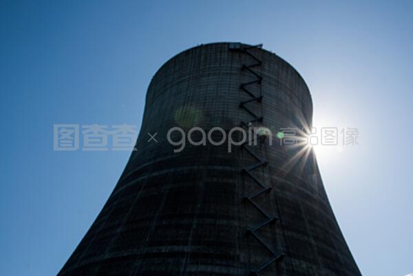 在藍(lán)色天空下的核冷卻塔有太陽(yáng)的爆發(fā)